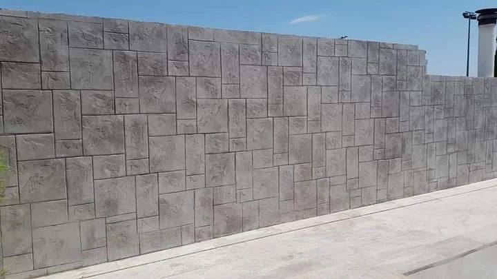 Revestimiento vertical decorativo con acabado de hormigón impreso efecto piedra, diseñado para dar textura y carácter al muro exterior con un resultado uniforme